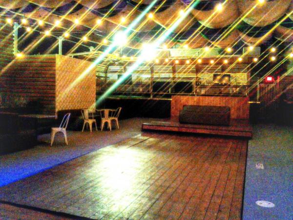 The deck at the Garden at night with a pool.